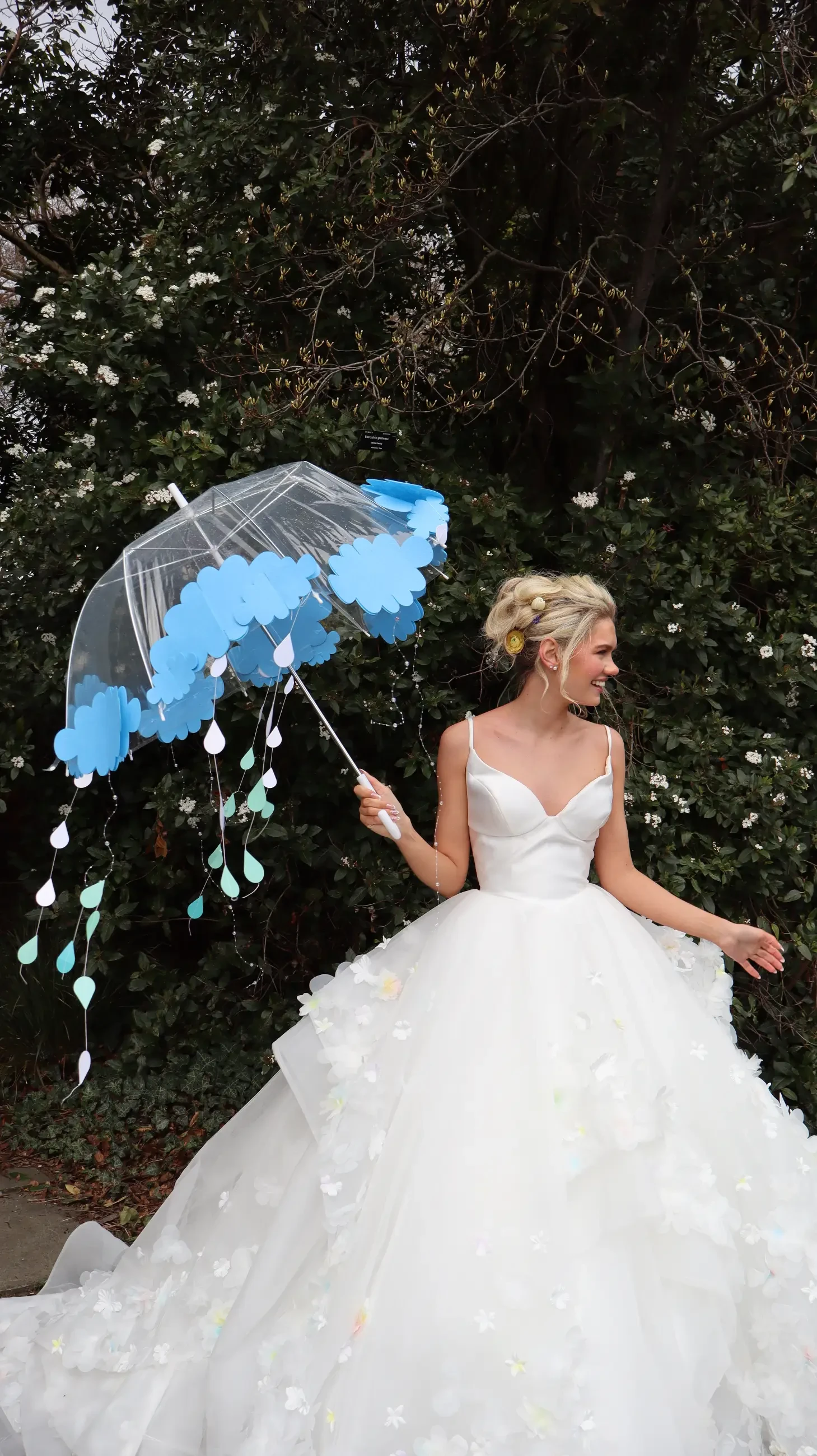 model wearing a bridal gown and holding an umbrella